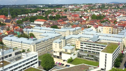  Aerial of Stuttgart, Bad Canstatt in Spring.  Camera rotates right over grass covered rooftops of office buildings, Mercedes Arena in the background.   photo