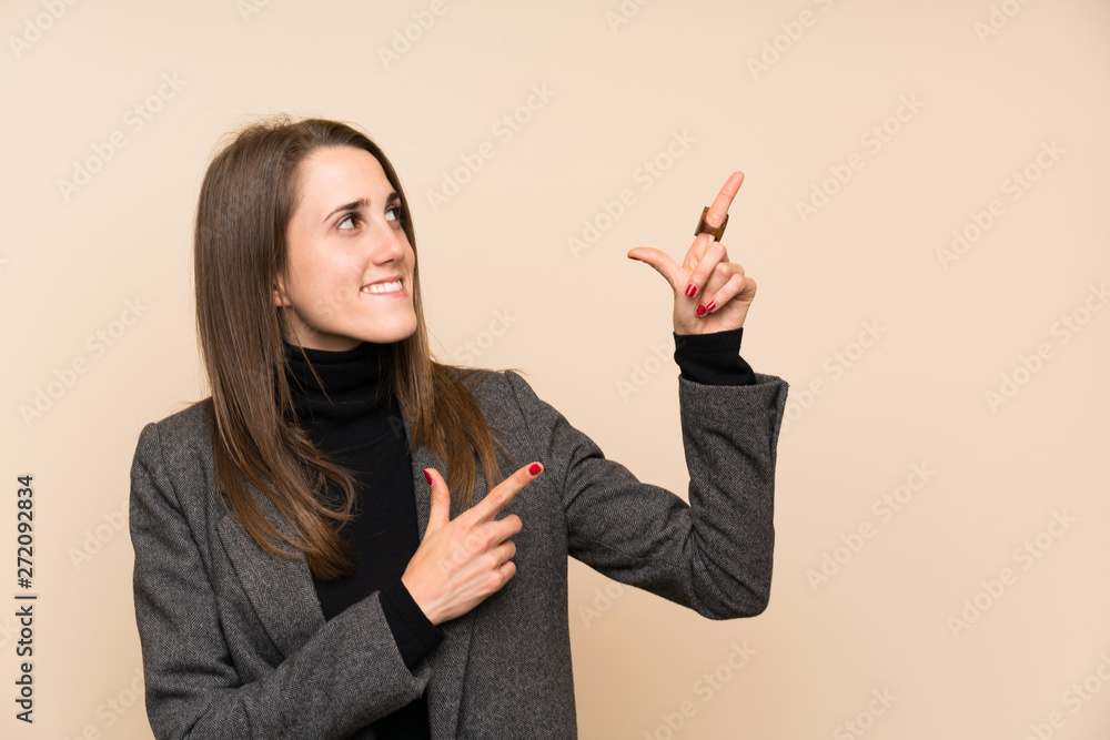 Young woman over isolated wall pointing with the index finger a great idea Young woman over isolated wall pointing with the index finger a great idea