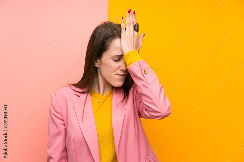 Young woman with pink suit over colorful background having doubts with confuse face expression Young woman with pink suit over colorful background having doubts with confuse face expression