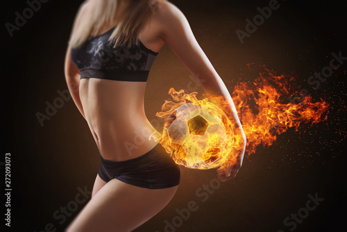 Woman holds soccer ball with fire photo