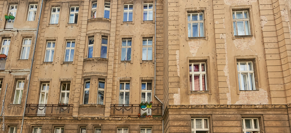 Berlin old building facade ridden with bullet holes, signs and scars of World War Two.