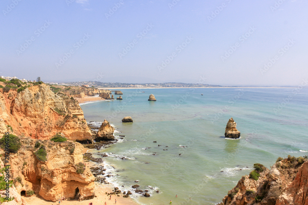 Panoramic landscape view of golden cliffs and emerald water in Camilo beach (Praia do Camilo) in Lagos, Algarve, Portugal