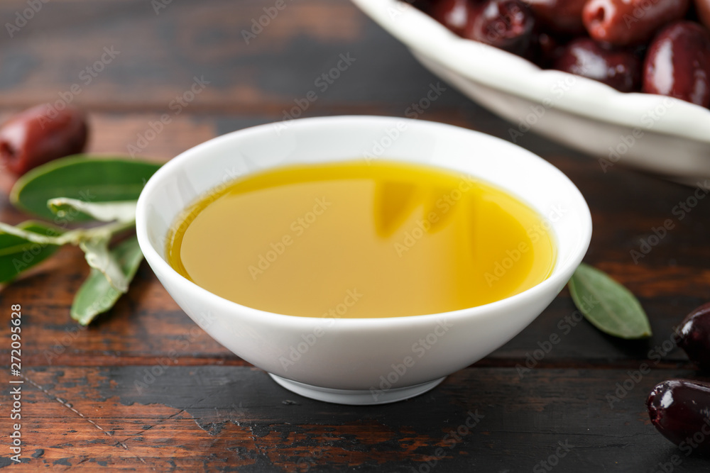 Extra virgin olive oil and kalamata olives on rustic wooden background Extra virgin olive oil and kalamata olives on rustic wooden background