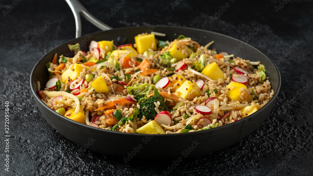 Asian style Vegan dish in pan with edamame, vegetable stir-fry mix, wholegrain rice, quinoa, mango chunks drizzled with mango, chilli dressing Asian style Vegan dish in pan with edamame, vegetable stir-fry mix, wholegrain rice, quinoa, mango chunks drizzled with mango, chilli dressing