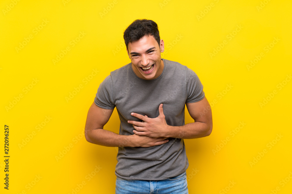 Handsome man over isolated yellow wall smiling a lot Handsome man over isolated yellow wall smiling a lot