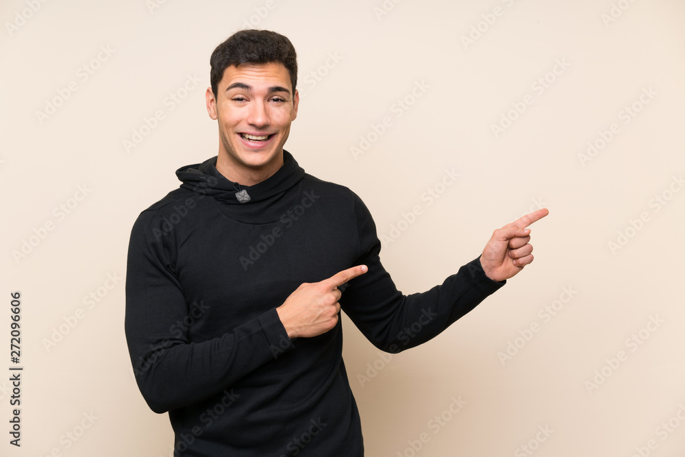 Handsome man over isolated background pointing finger to the side Handsome man over isolated background pointing finger to the side