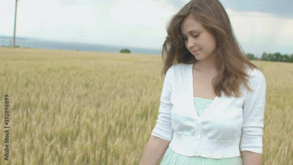 beautiful girl walking and enjoying nature in a field of cereal ears, a young woman rests emotionally and physically, relax beautiful girl walking and enjoying nature in a field of cereal ears, a young woman rests emotionally and physically, relax