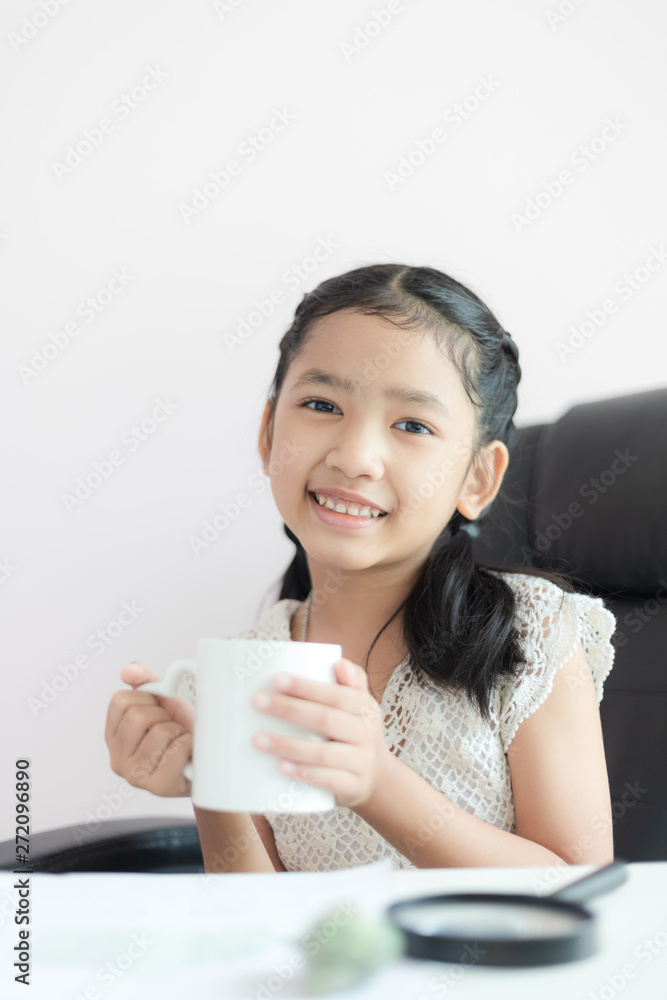 Little Asian girl holding white mug and smile with happiness select focus shallow depth of field Little Asian girl holding white mug and smile with happiness select focus shallow depth of field