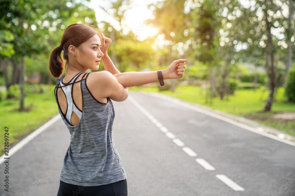 Rear view of woman stretching her arm and shoulder. Women stretching for warming up before running or working out. Fitness and healthy lifestyle concept.