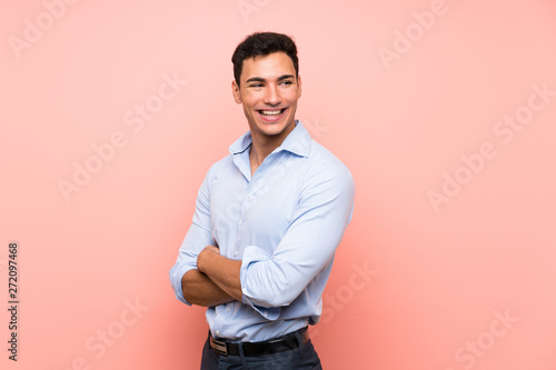 Handsome man over pink background with arms crossed and happy © luismolinero