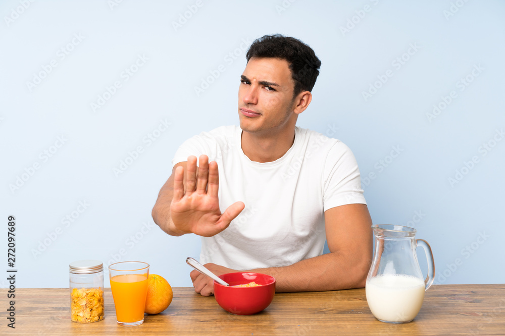 Handsome man in having breakfast making stop gesture with her hand Handsome man in having breakfast making stop gesture with her hand