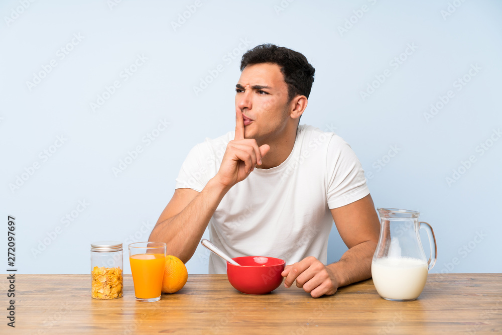 Handsome man in having breakfast doing silence gesture Handsome man in having breakfast doing silence gesture