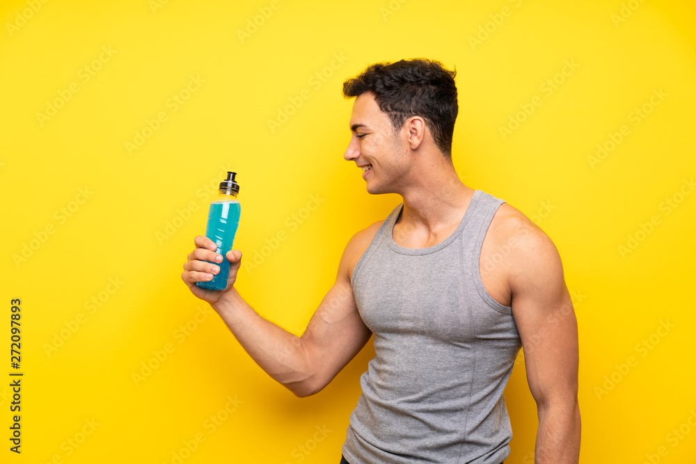 Handsome sport man over isolated background with a bottle of soda Handsome sport man over isolated background with a bottle of soda