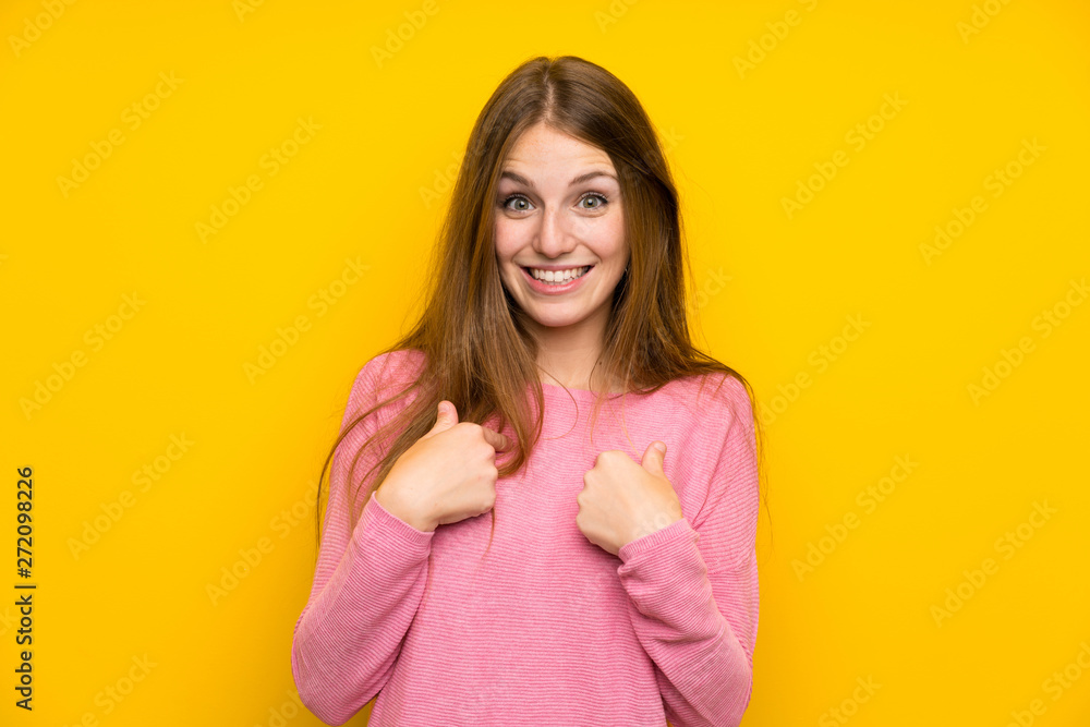 Young woman with long hair over isolated yellow wall with surprise facial expression Young woman with long hair over isolated yellow wall with surprise facial expression