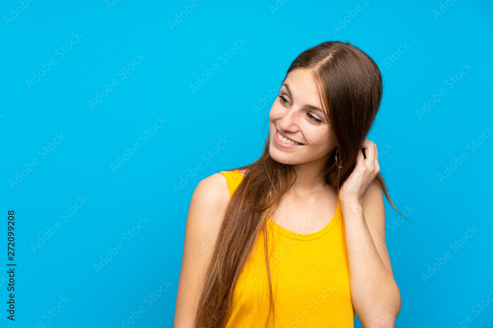 Young woman with long hair over isolated blue wall thinking an idea Young woman with long hair over isolated blue wall thinking an idea