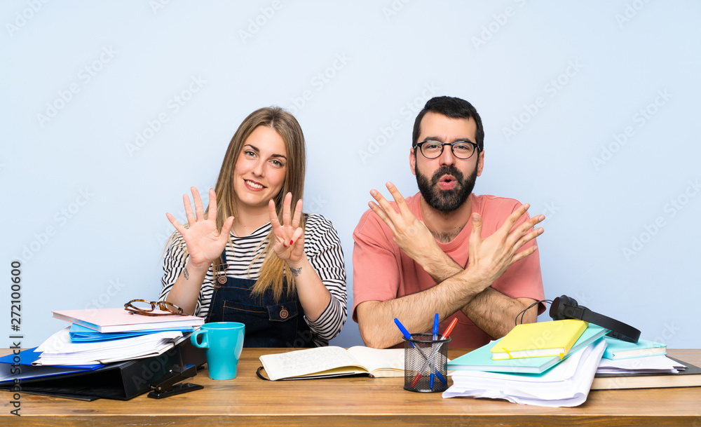 Students with many books counting eight with fingers Students with many books counting eight with fingers