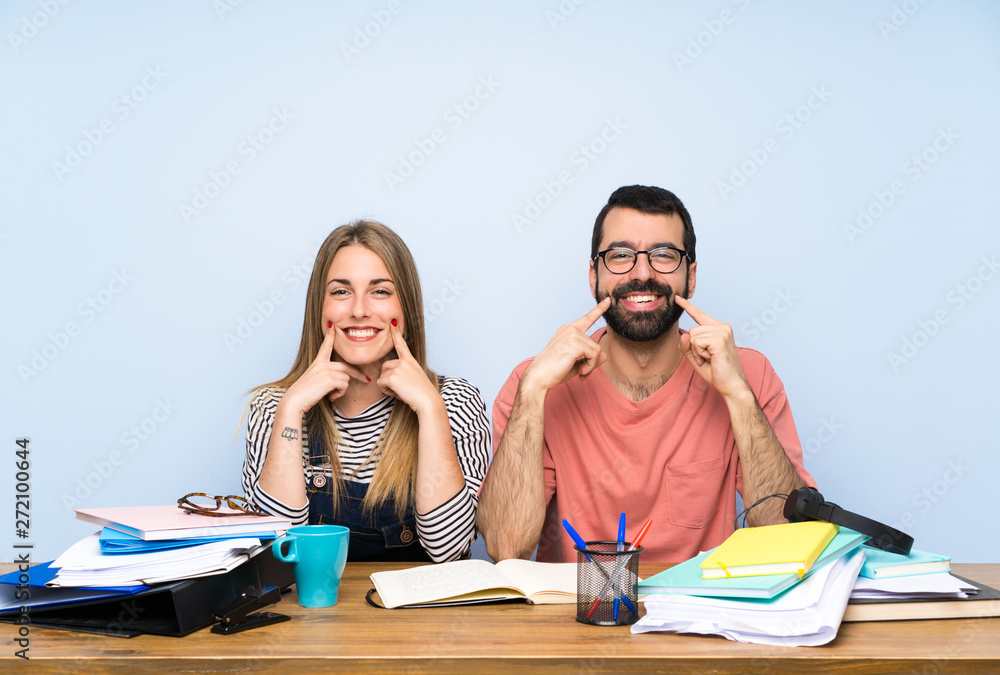 Students with many books smiling with a happy and pleasant expression Students with many books smiling with a happy and pleasant expression