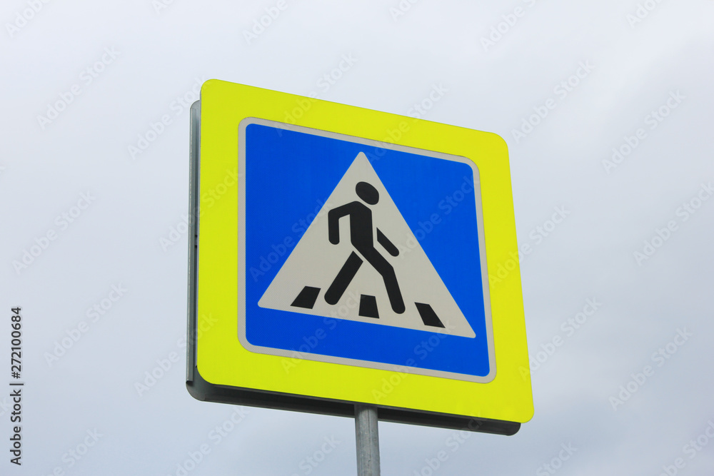 Pedestrian crosswalk street sign close up view on empty sky background Pedestrian crosswalk street sign close up view on empty sky background