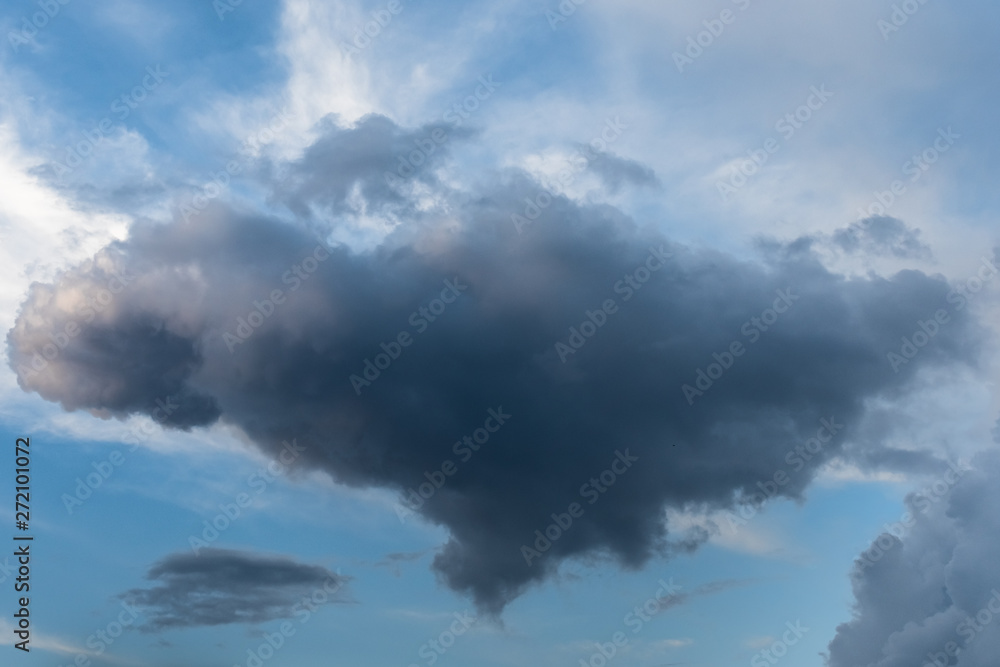 Dark cloud in a reminiscent of heart on the background of a bright evening sky.