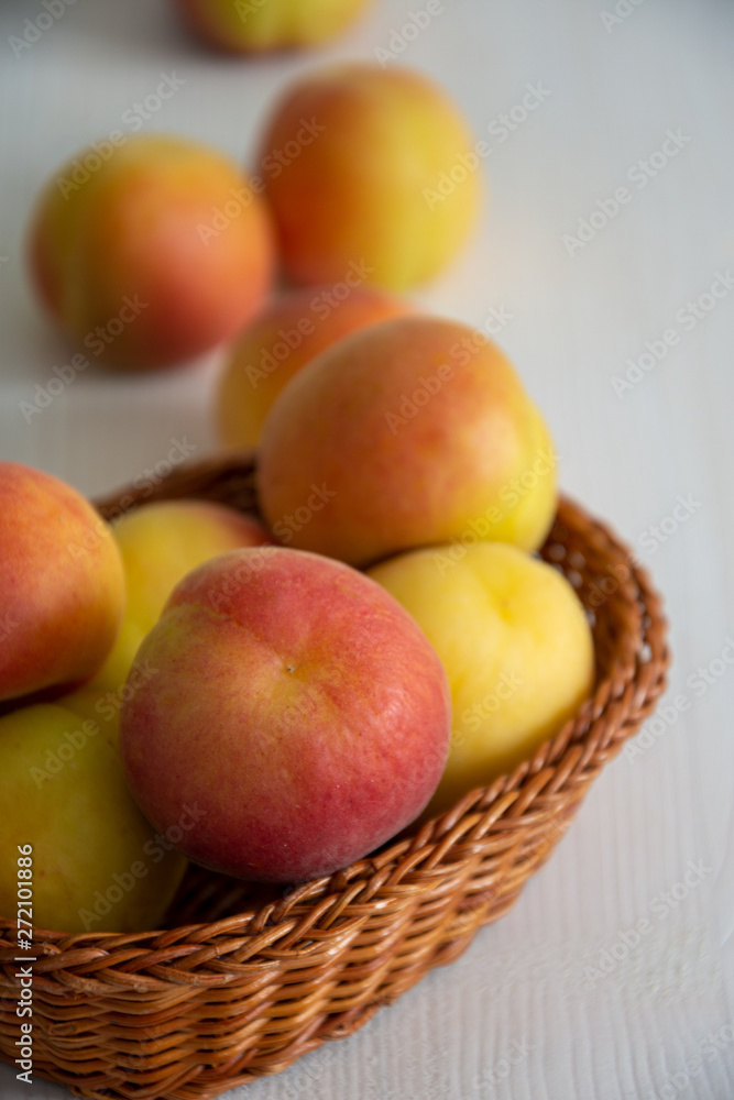 Top view of apricots in basket on white wooden background in vertical Top view of apricots in basket on white wooden background in vertical