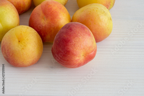 Top view of apricots on white wooden background