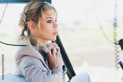 Female pilot in cockpit of helicopter before take off. Young woman helicopter pilot. photo