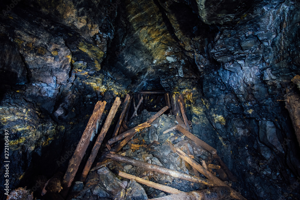 Fototapeta premium Abandoned coal mine with rotten collapsed wooden miner stands. Old derelict coal development