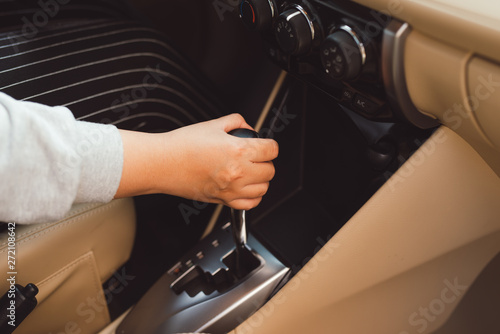 woman switches the automatic transmission's close-up. Close-up of the driver's adm includes mode Drive on the gear lever automatic transmission of the car interior parts