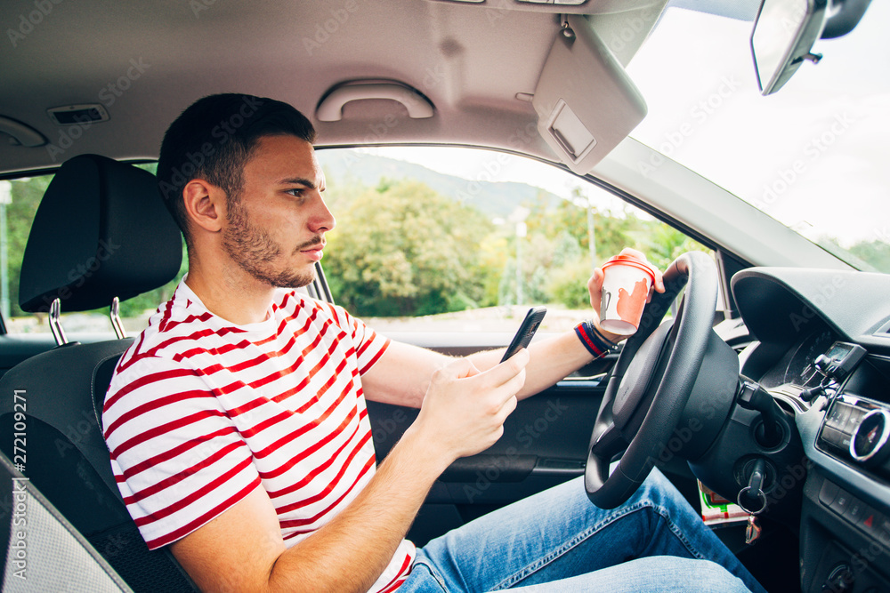 Naklejka premium Guy in a car with coffee and phone