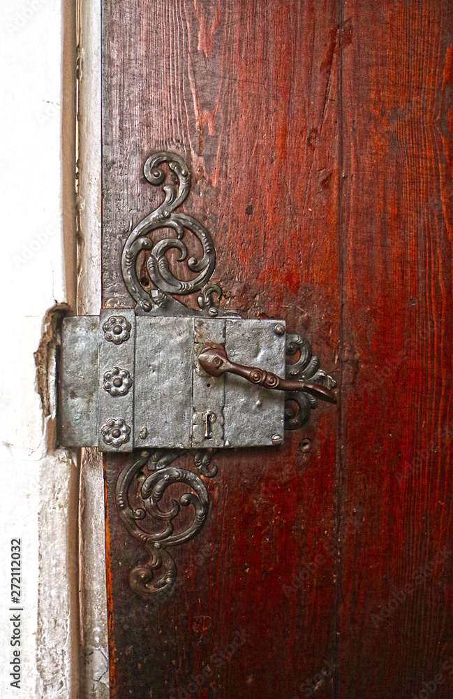 details of an old church wooden door: bronze handle, wrought iron decorations and lock details of an old church wooden door: bronze handle, wrought iron decorations and lock