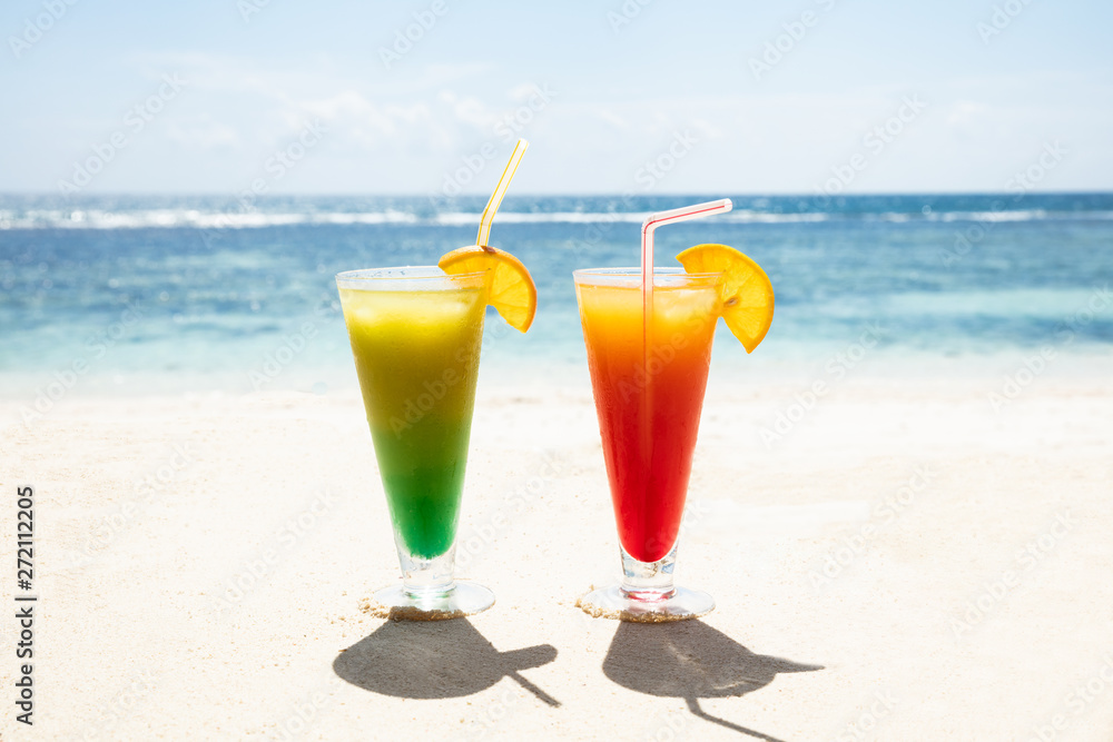 Obraz premium Two Glasses Of Cocktails On The Sandy Beach