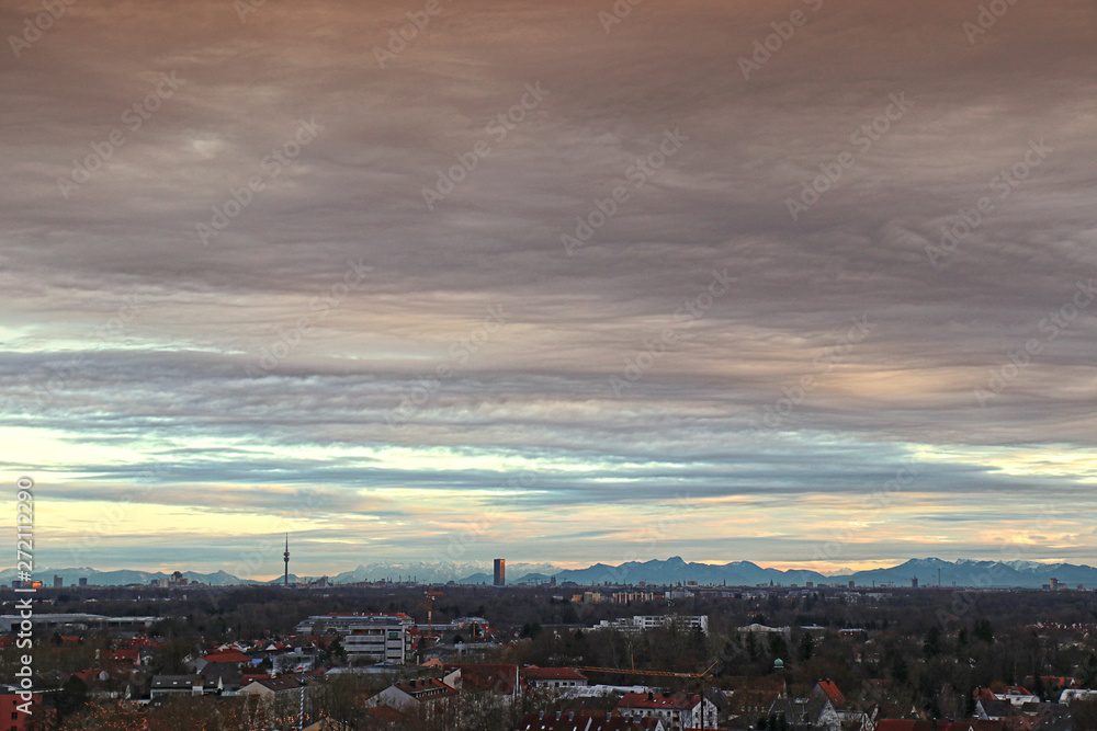 Aerial view of a Bavarian rural panorama at twilight with exceptional clear visibility and the view of the Olympia tower in Munich and the faraway Alps mountains