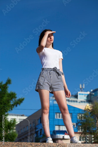 Smiling brunette model in white summer blouse, summer street outdoors