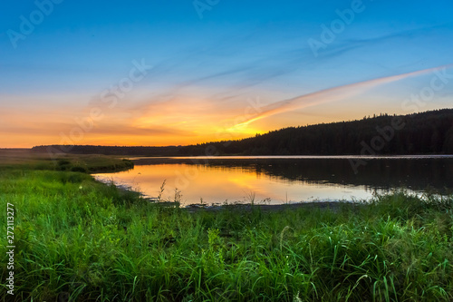 Beautiful sunset over the lake in the countryside in summer.