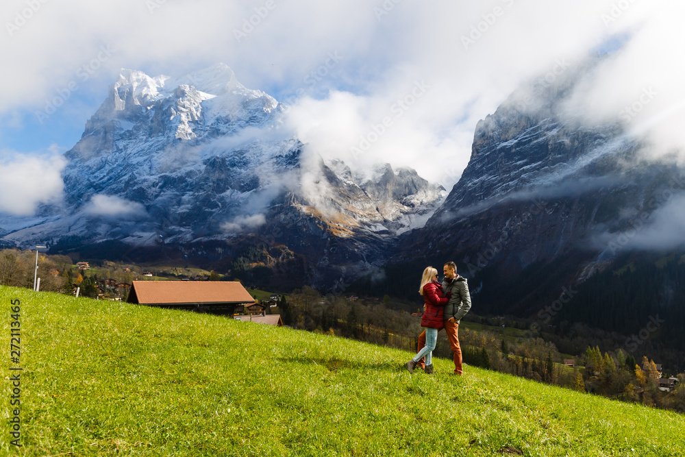 Young couple of travelers enjoying a mountains view, Grindelwald Switzerland
