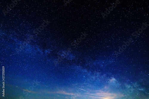 Starry sky and the milky way over the meadow and forest.