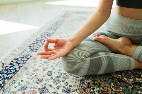 Young attractive smiling woman practicing yoga in a stylish room photo