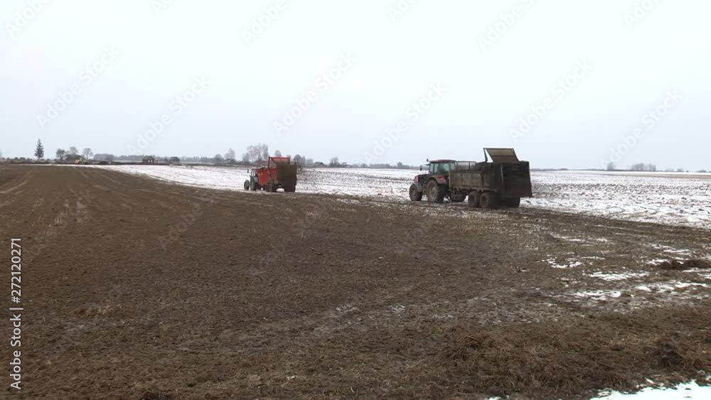 A farmer using a manure spreader behind his tractor to spread an organic mixture of manure and hay on his land for fertilisation. Manure is used as fertilizer in agriculture. Concept: agriculture A farmer using a manure spreader behind his tractor to spread an organic mixture of manure and hay on his land for fertilisation. Manure is used as fertilizer in agriculture. Concept: agriculture