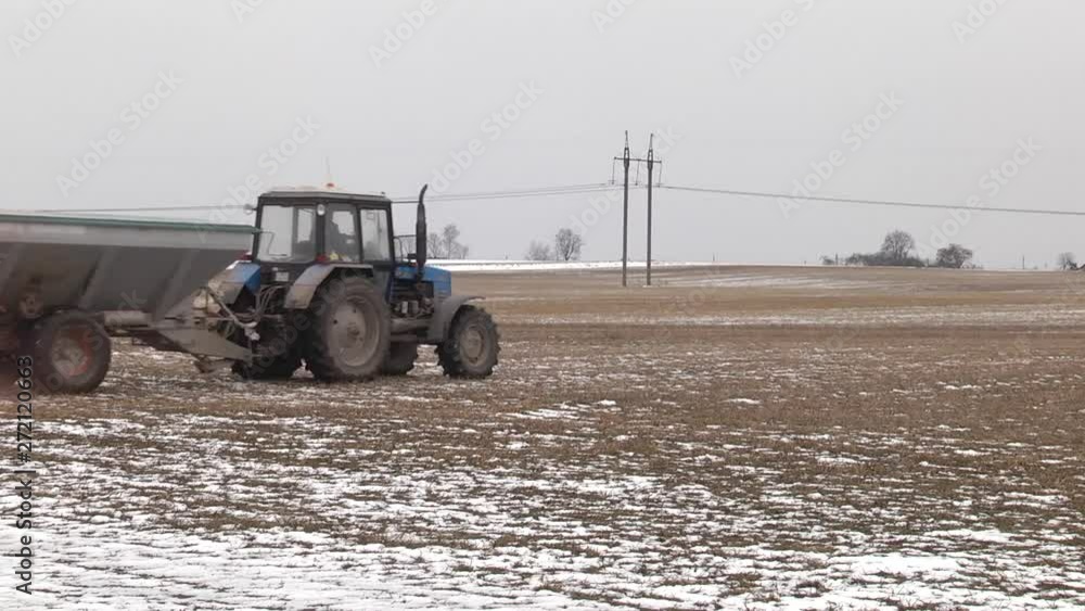 Vidéo Stock A farmer using a manure spreader behind his tractor to