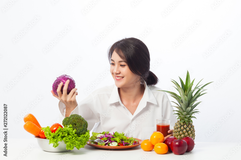 Young women like to eat vegetables, A girl love tomato and vegetables, Asian woman love vegetables and smiling with violet cabbage on white background. 