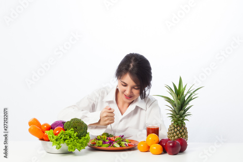 Young women do not like to eat vegetables. Asian woman tired of eating vegetables. Diet of asian girl on white background.