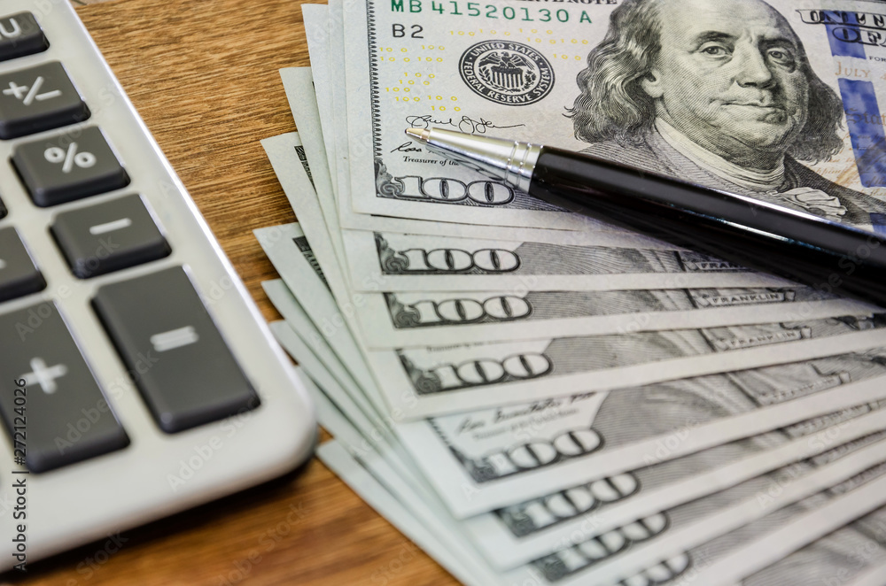 pen with dollars and calculator close up. View from above. pen with dollars and calculator close up. View from above.