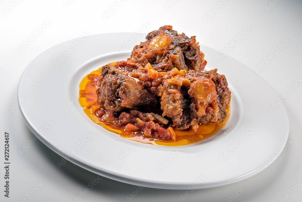 Isolated Dish with a portion of oxtail stewed vaccinara Isolated Dish with a portion of oxtail stewed vaccinara