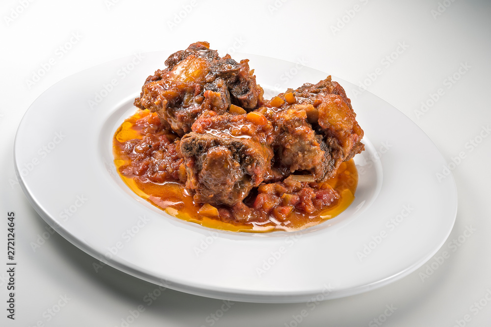 Isolated Dish with a portion of oxtail stewed vaccinara Isolated Dish with a portion of oxtail stewed vaccinara