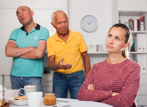 Elderly father together with his adult son scold the daughter-in-law at home