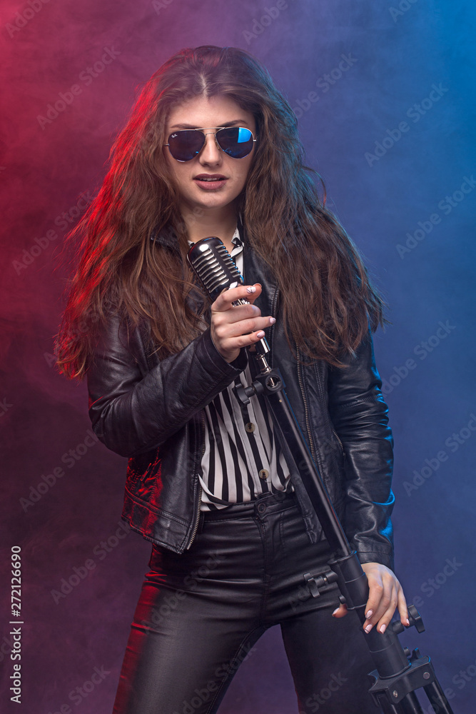 Expressive rock star style girl singing with a old microphone, Lifestyle Concept Expressive rock star style girl singing with a old microphone, Lifestyle Concept