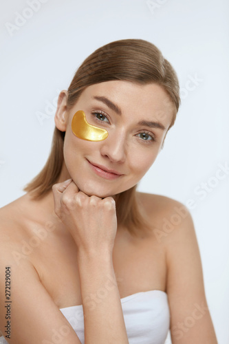 Fototapet Skin care. Woman face with under eye gold patch, beauty mask