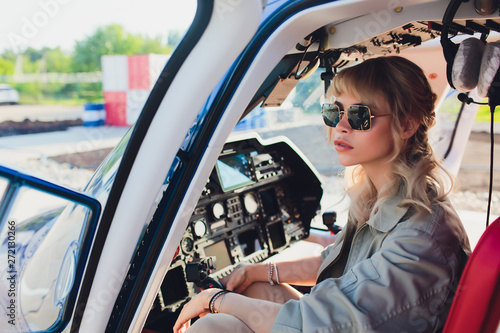 Female pilot in cockpit of helicopter before take off. Young woman helicopter pilot. photo