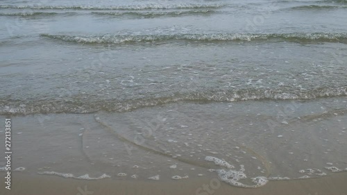 Close up female walking along sandy beach background of ocean waves, in thailand
