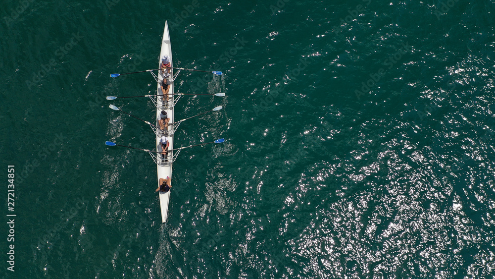 Obraz premium Aerial drone bird's eye view of sport canoe operated by team of young trained athletes in deep blue Aegean sea